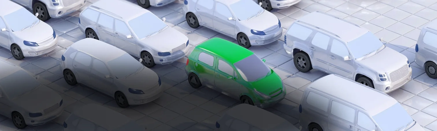 A green car in the midst of white cars.