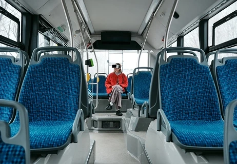Commuter using a VR headset for entertainment on a bus, powered by Bold Miles.