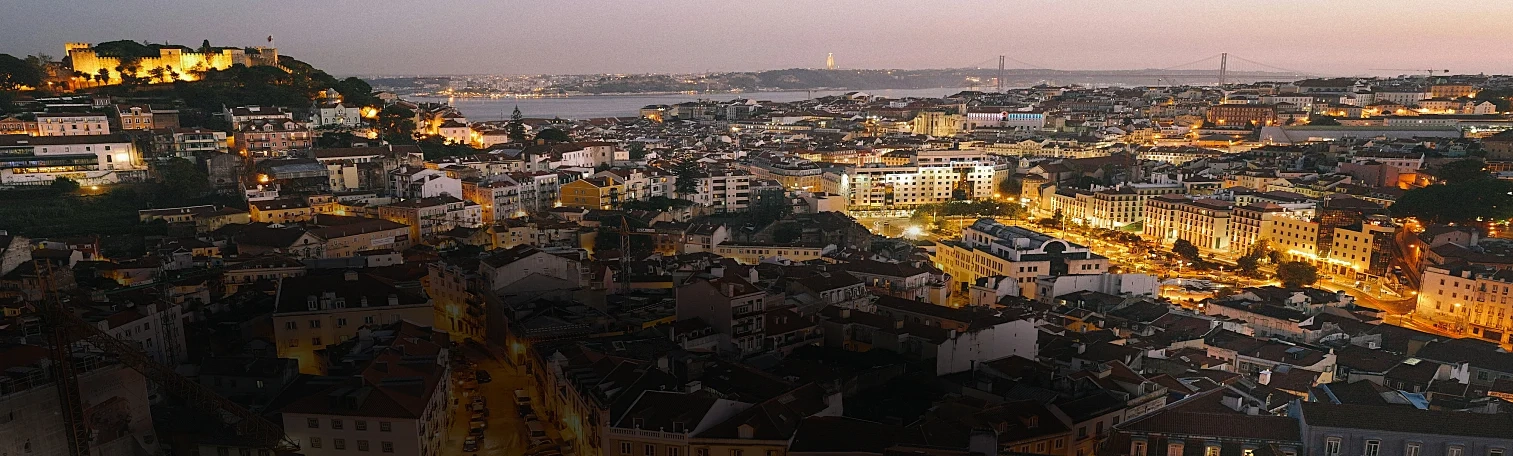 An urban city lit up with lights at dusk.